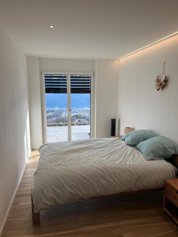 Ένα ή περισσότερα κρεβάτια σε δωμάτιο στο Appartement moderne avec vue panoramique à Jongny proche de Montreux