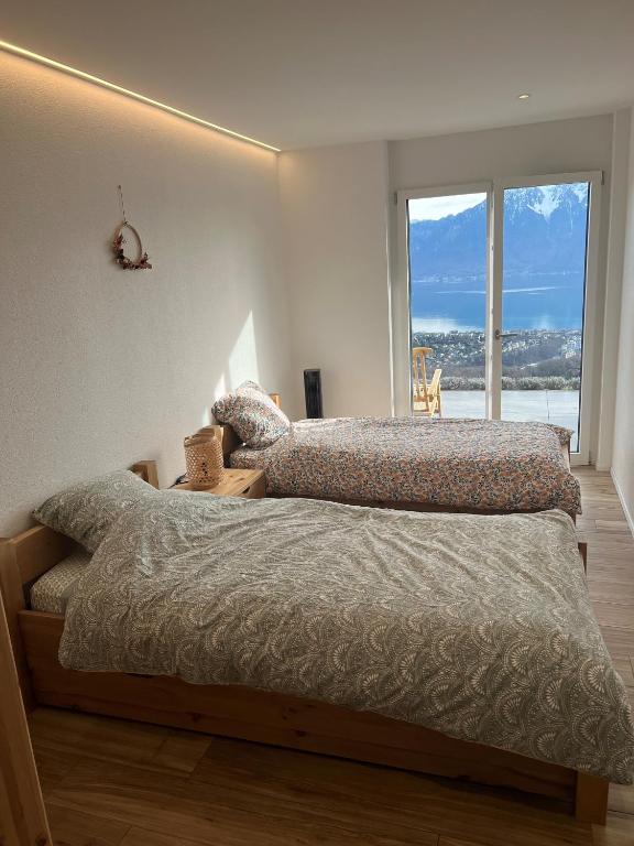 Ένα ή περισσότερα κρεβάτια σε δωμάτιο στο Appartement moderne avec vue panoramique à Jongny proche de Montreux