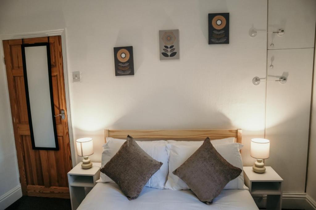 una camera con un letto con due lampade e due altoparlanti di 63 Westmorland St by Prestige Properties SA a Barrow in Furness