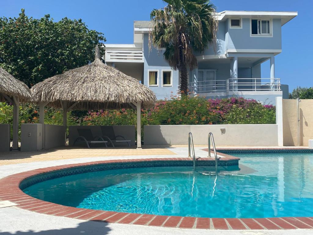 een zwembad voor een huis bij Villa at secured gated resort near Mambo Beach! in Willemstad