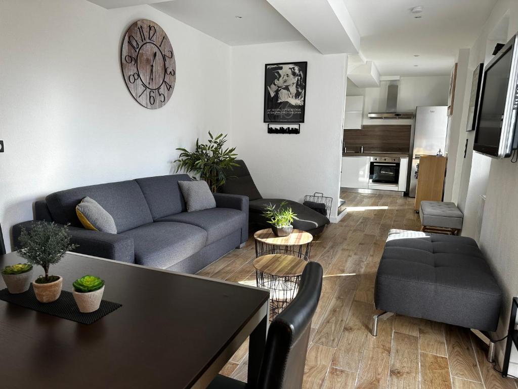 uma sala de estar com um sofá e uma mesa em Villa Cocooning proche Cannes em Vallauris