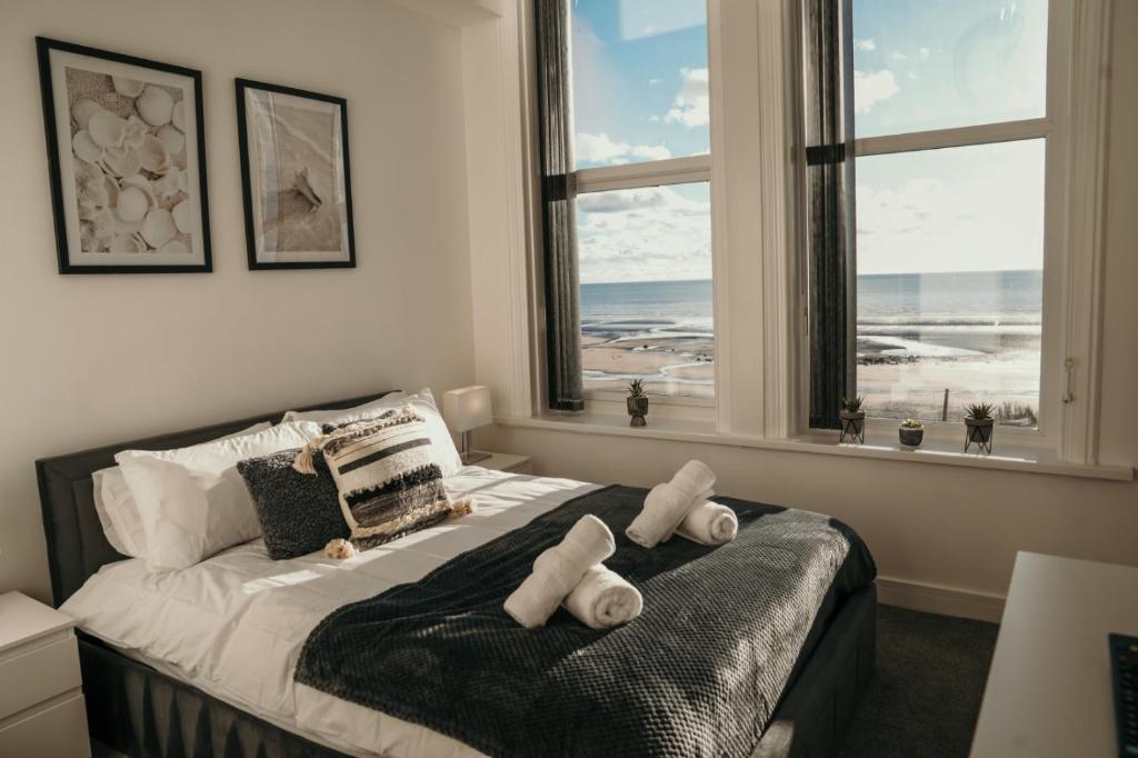 a bedroom with a bed with a view of the ocean at 6 Burnett by Prestige Properties SA in Seascale