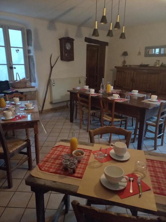 jadalnia z drewnianymi stołami i krzesłami w obiekcie CHAMBRES D'HOTES L'ANTONIN w mieście Saint-Antoine