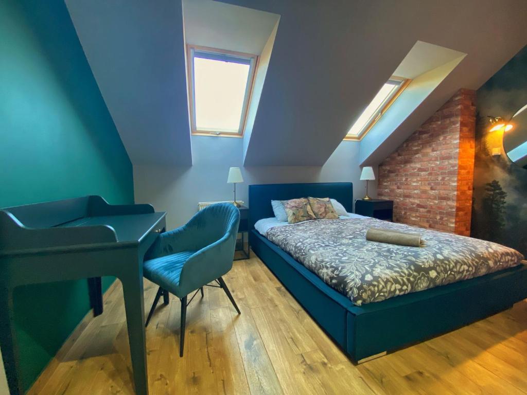 um quarto com uma cama azul e uma secretária em Angelika 9A/3 Mountain Aparts em Świeradów-Zdrój