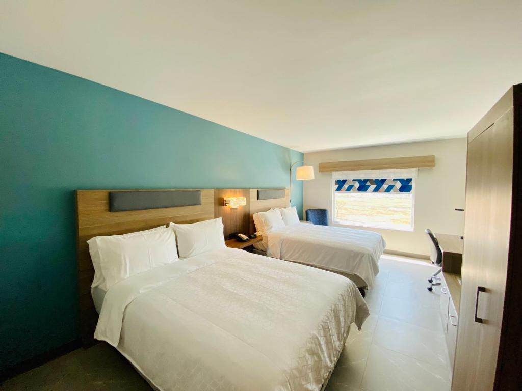 a hotel room with two beds and a window at Holiday Inn Express - Guadalajara Vallarta Poniente, an IHG Hotel in Guadalajara