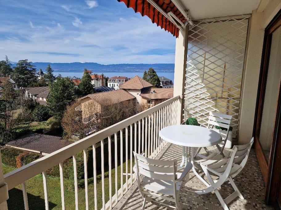 una mesa blanca y sillas en un balcón con vistas en Au Beau Voyage à 2 pas des Thermes, en Thonon-les-Bains
