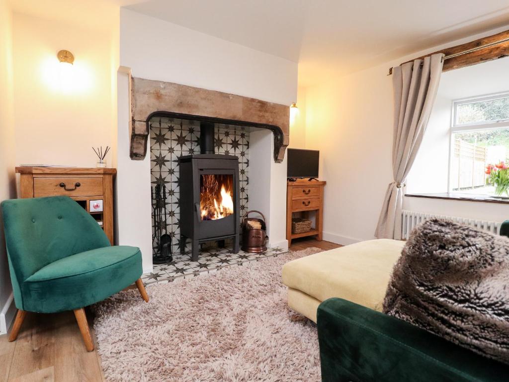 a bedroom with a fireplace and a green chair at Tilly's Place in Heysham