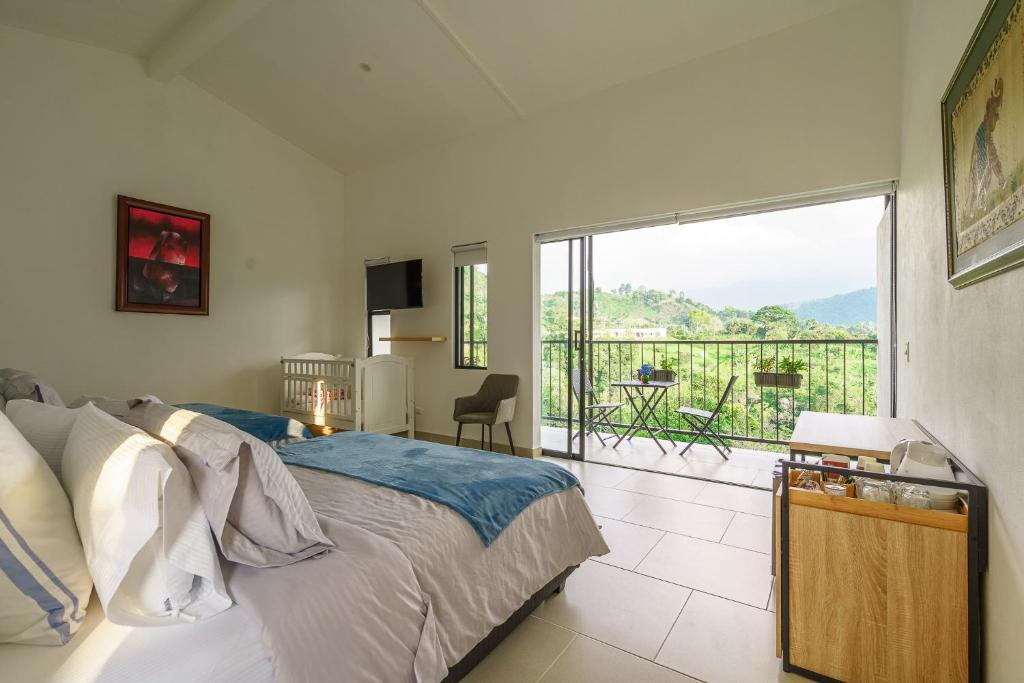 a bedroom with a bed and a balcony with a view at Acaima Café Lodge in Sasaima