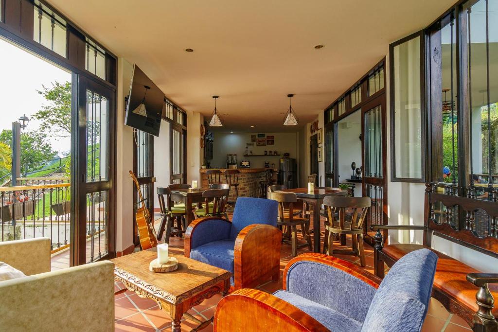 a restaurant with chairs and tables and windows at Acaima Café Lodge in Sasaima