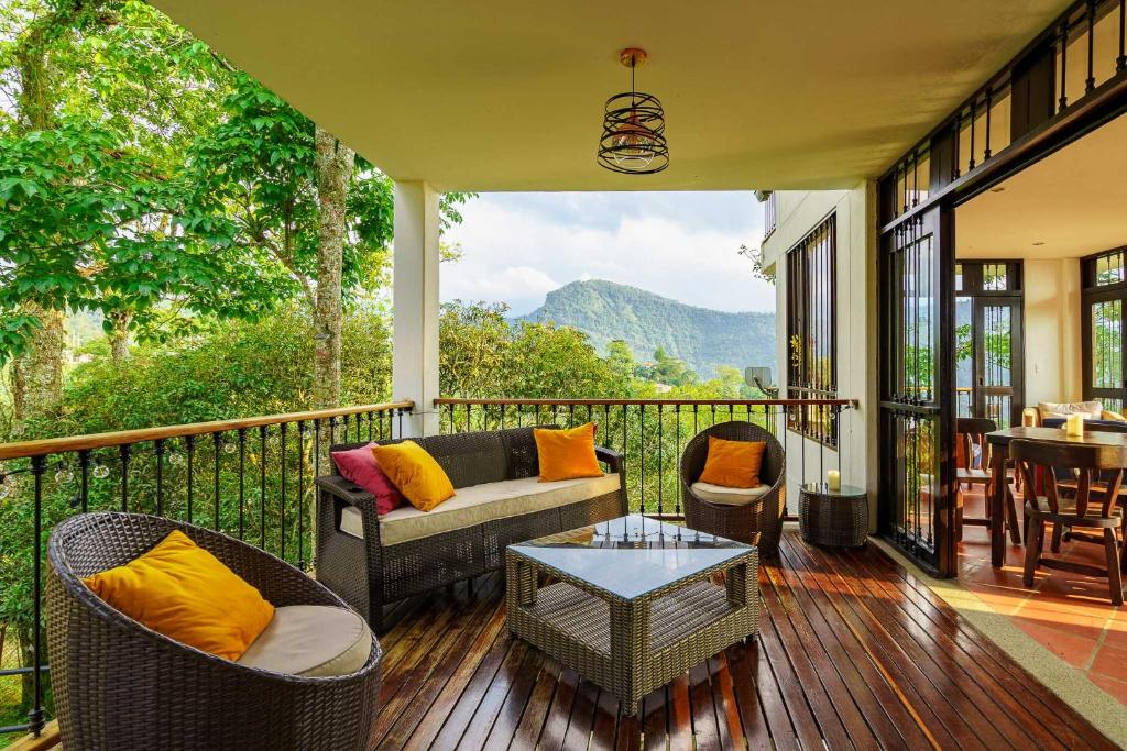 a porch with a couch and chairs and a table at Acaima Café Lodge in Sasaima