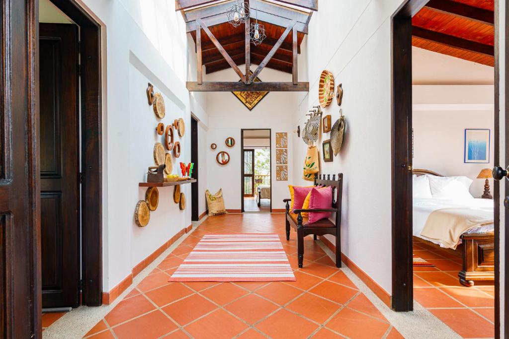 a hallway with a bedroom with a bed and a chair at Acaima Café Lodge in Sasaima