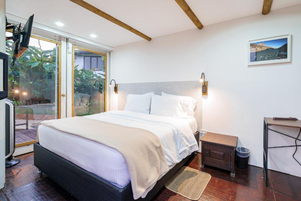 a bedroom with a large bed and a television at Acaima Café Lodge in Sasaima