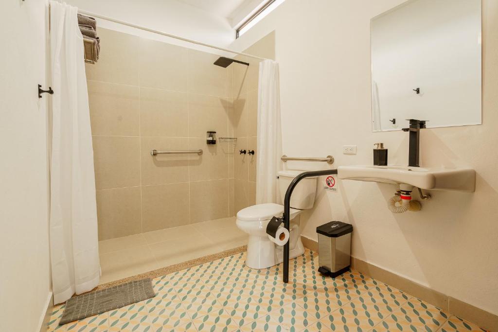 a bathroom with a shower and a toilet and a sink at Acaima Café Lodge in Sasaima