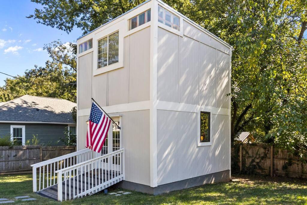 Uma pequena casa branca com uma bandeira americana. em Downtown Guest House em Raleigh