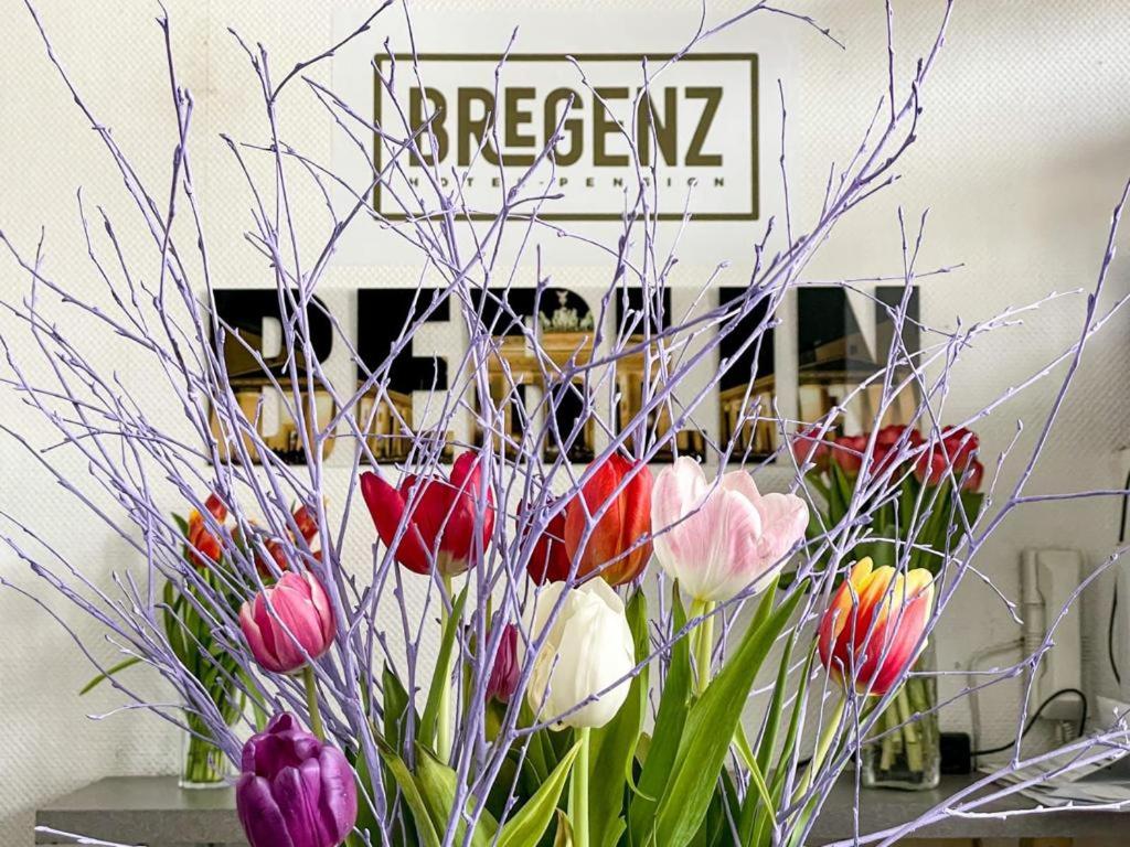 un vaso pieno di fiori colorati su un tavolo di Hotel Bregenz a Berlino