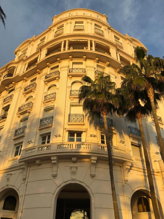 wysoki budynek z palmą przed nim w obiekcie PALACE ROOM CROISETTE w Cannes