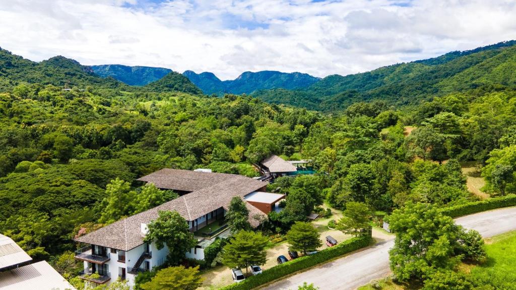 una vista aerea di una casa con montagne sullo sfondo di Rain Tree Residence Hotel a Phayayen
