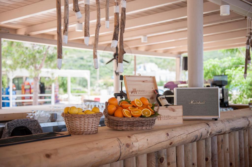 a counter with two baskets of oranges and a laptop at Soleil Village & Villas in Jal