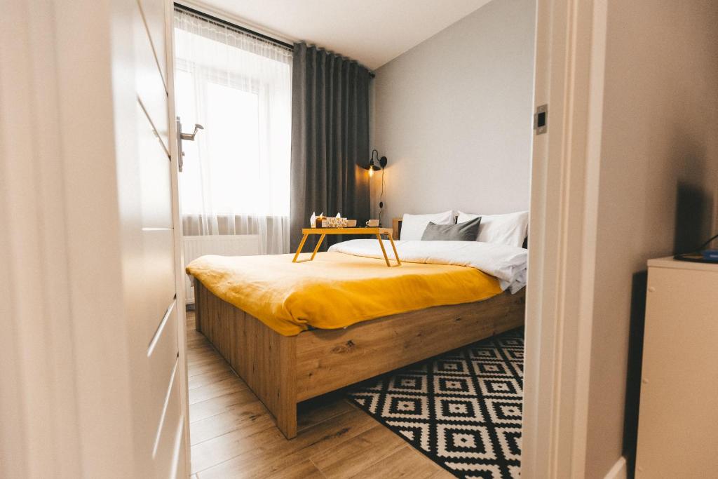 1 dormitorio con 1 cama con manta amarilla y ventana en BAVOVNA Нова комфортна 2-кімн. квартира в ЖК Енергія, en Ternopilʼ
