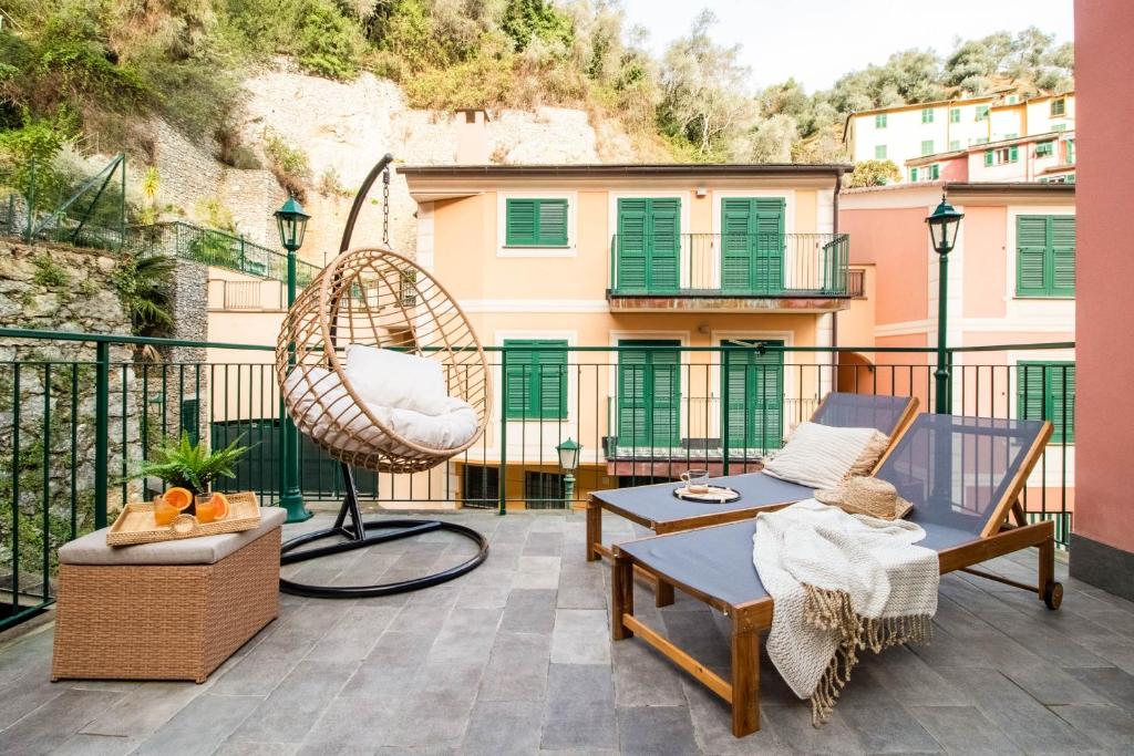 eine Terrasse mit Stühlen und einer Schaukel auf dem Balkon in der Unterkunft Olives Bay Terrace in Portofino in Portofino