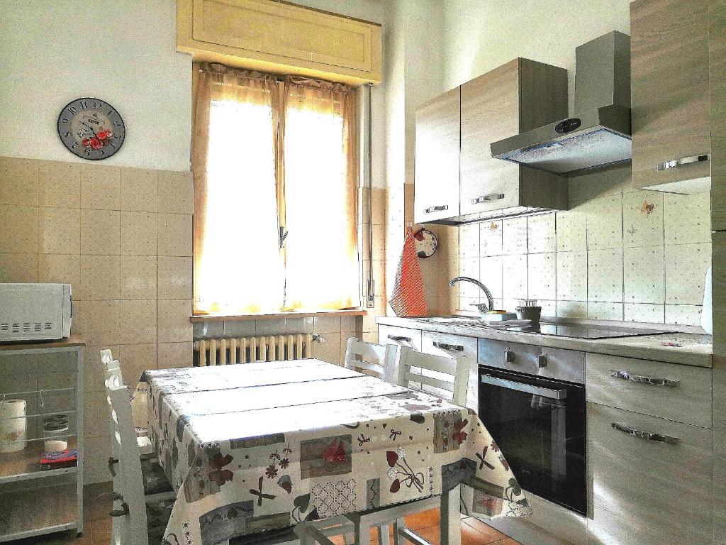 une cuisine avec une table et des chaises ainsi qu'une fenêtre dans l'établissement Novara Suite, à Novara