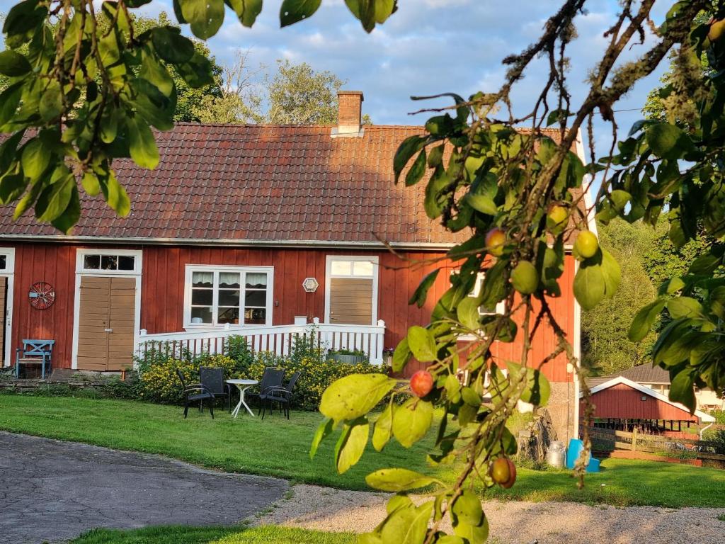 une maison rouge avec un arbre devant elle dans l'établissement Fageredsgården, à Ullared