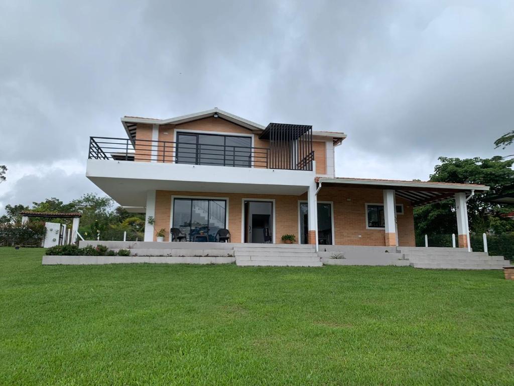 une maison avec une grande pelouse devant elle dans l'établissement Casa Campestre Altamira, à Los Curos