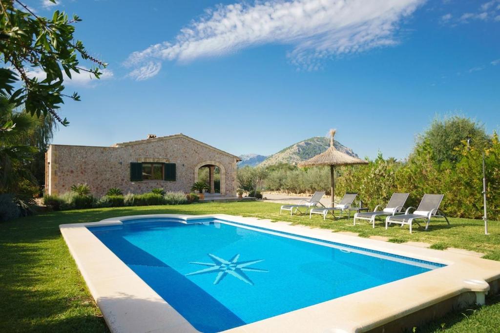 a swimming pool in front of a house at Villa Antonia, Pollença in Pollença