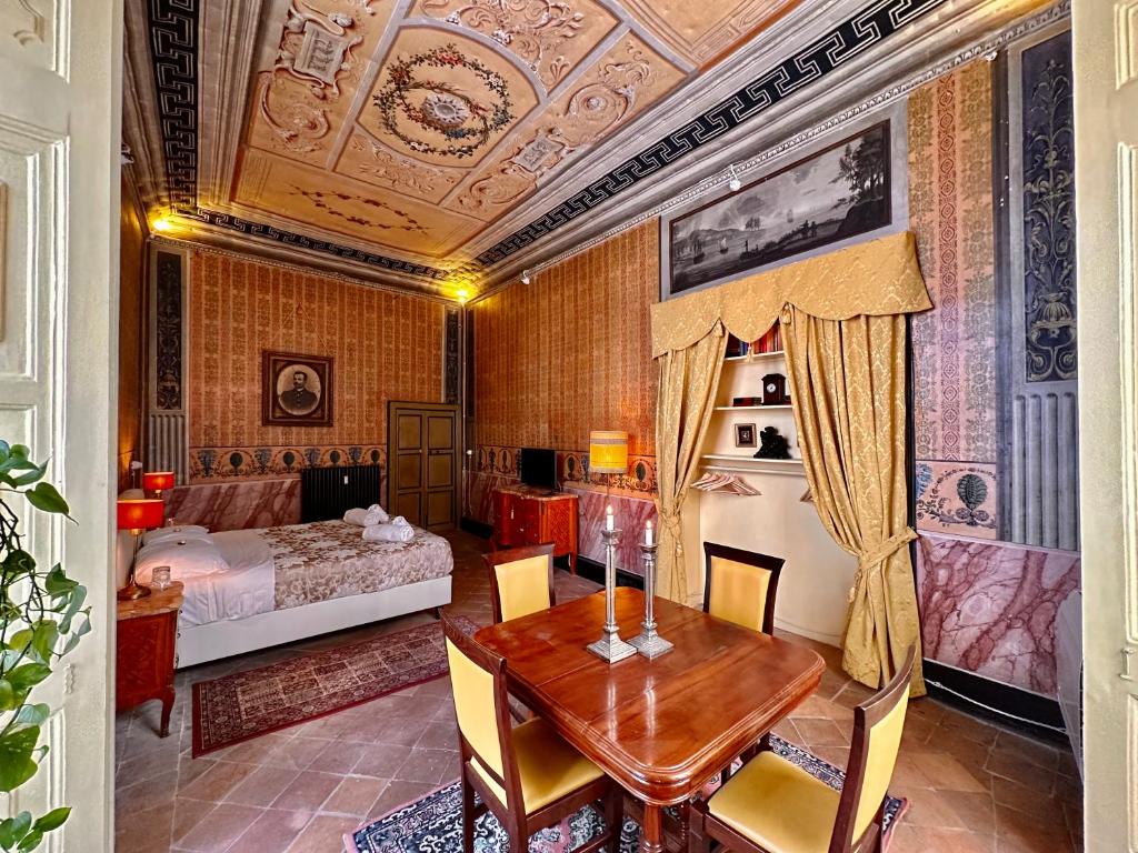 a dining room with a table and a bedroom at Casa Santangelo Suites in Salerno