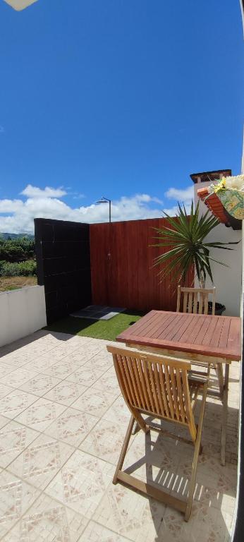 a wooden table and a bench on a patio at Casa Da Torre in Ribeira Grande