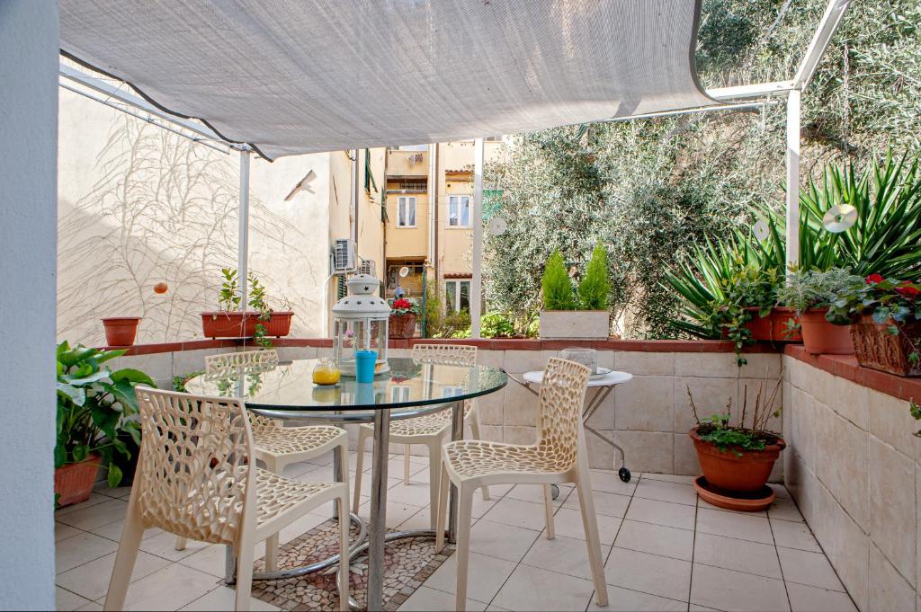 a table and chairs on a patio with plants at Casina di Alo e Ala in Livorno