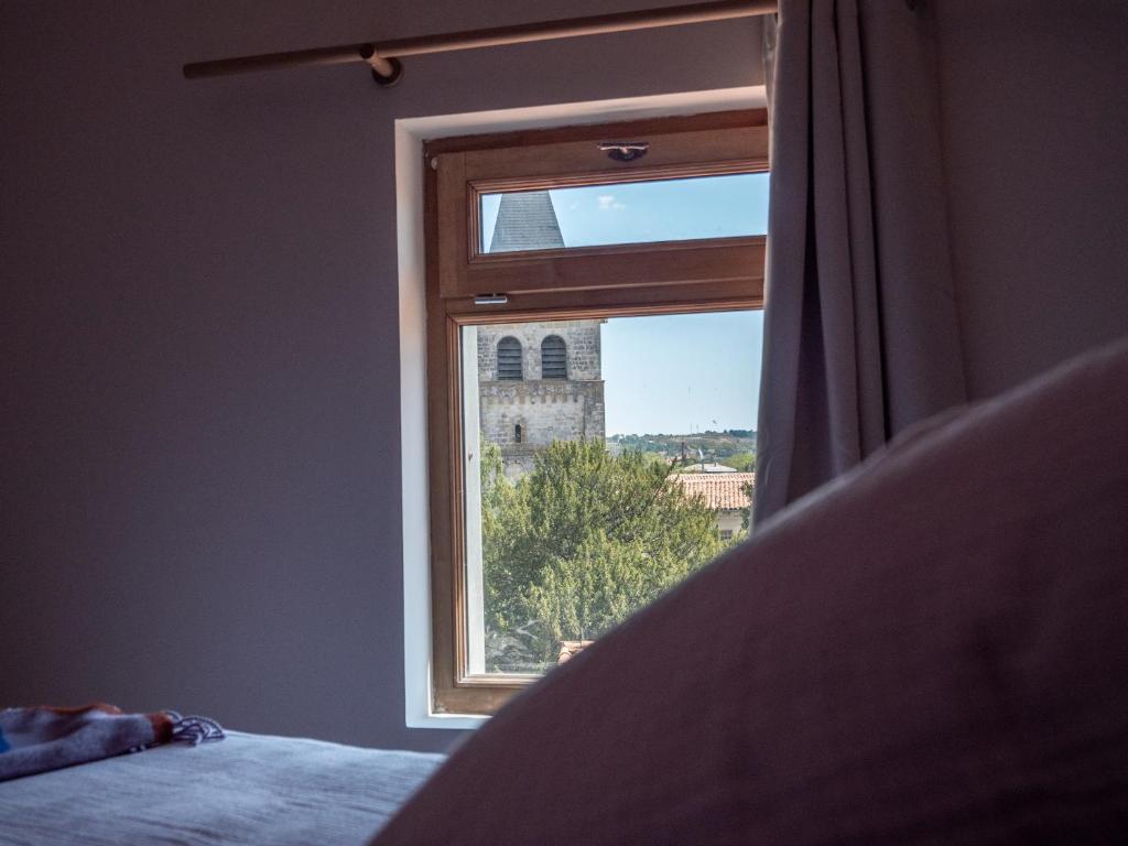 a bedroom with a window with a view of a tower at LE NID BLEU Duplex en plein centre in Castres