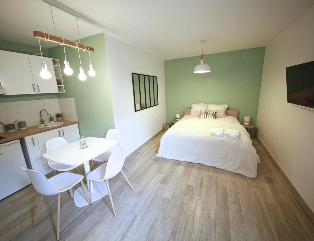 a bedroom with a bed and a table and chairs at Studio Disneyland Paris in Montévrain