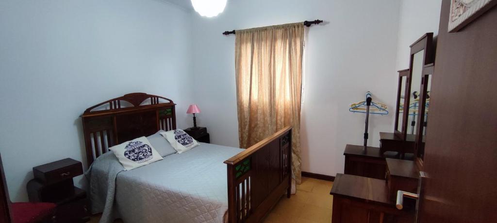a bedroom with a bed with white sheets and pillows at Casa Da Torre in Ribeira Grande