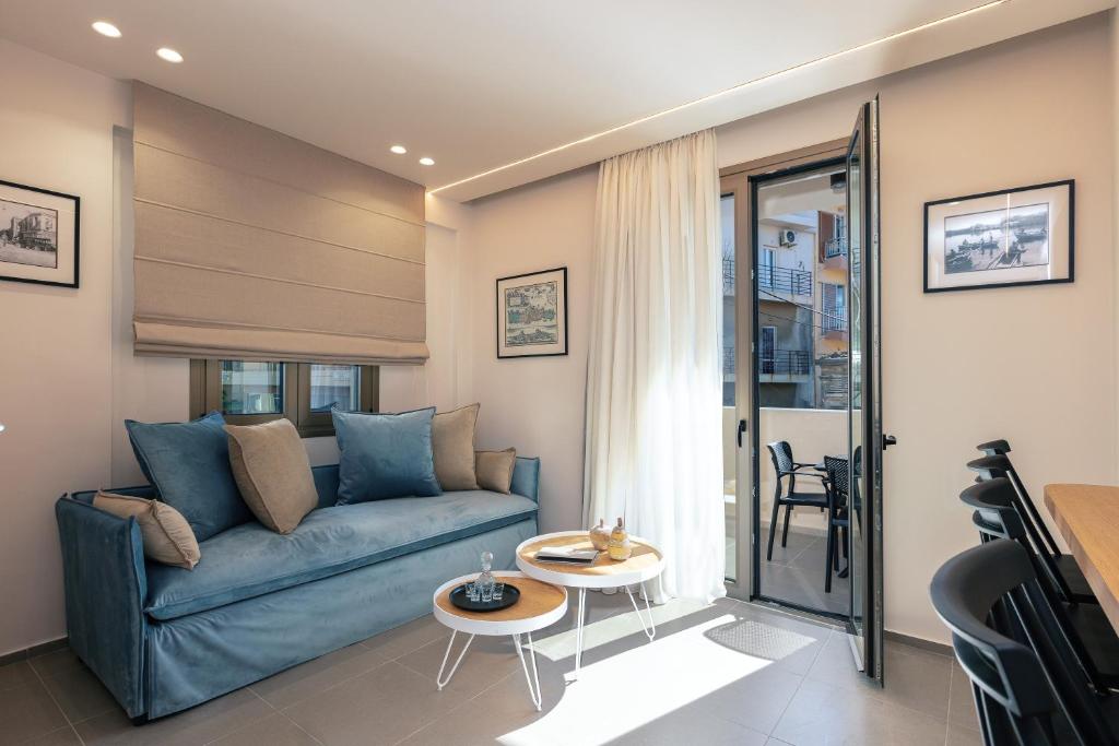 ein Wohnzimmer mit einem blauen Sofa und einem Tisch in der Unterkunft Old City Apartments in Iraklio