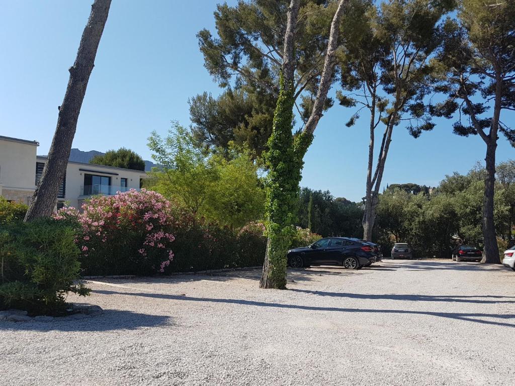 a parking lot with palm trees and a car at HPC Suites - Cassis Centre - Parking Gratuit & Piscine Chauffée in Cassis