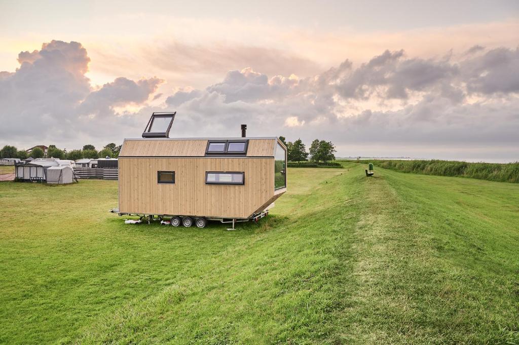 a tiny house is sitting in a field at Tiny House Pioneer 2 - Hooksiel im Wangerland in Wangerland