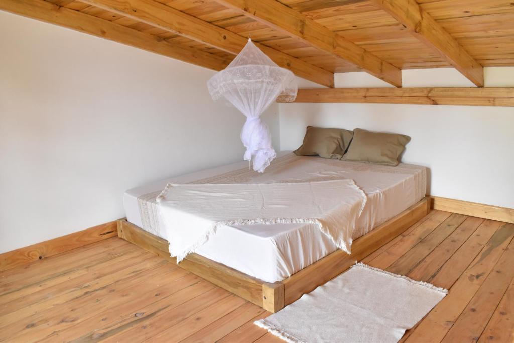 a bed in a room with a wooden ceiling at Tiny house with amazing view in Arusha