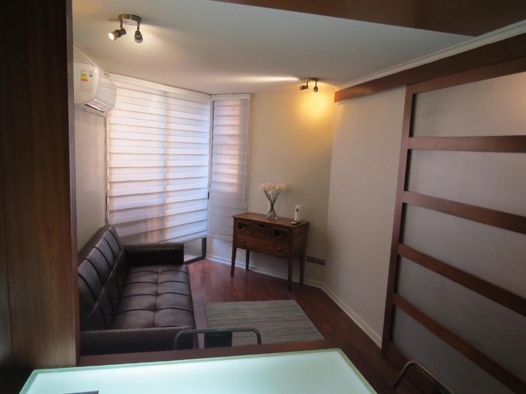 een woonkamer met een bank en een tafel bij Cómodo y elegante departamento in Santiago