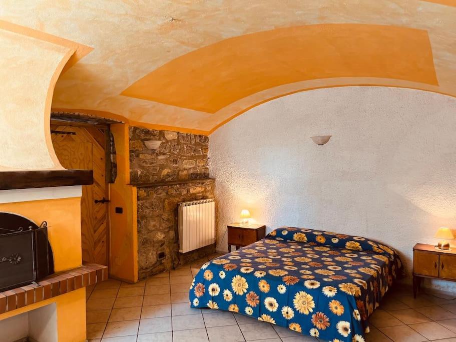 een slaapkamer met een bed en een stenen muur bij La Tuga appartamento stile marinaro sul mare in Imperia