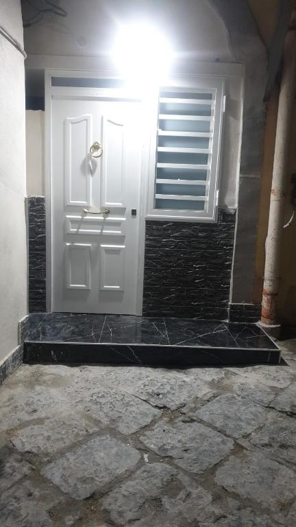 una puerta blanca con una ventana y una pared de ladrillo en House Milly, en Nápoles