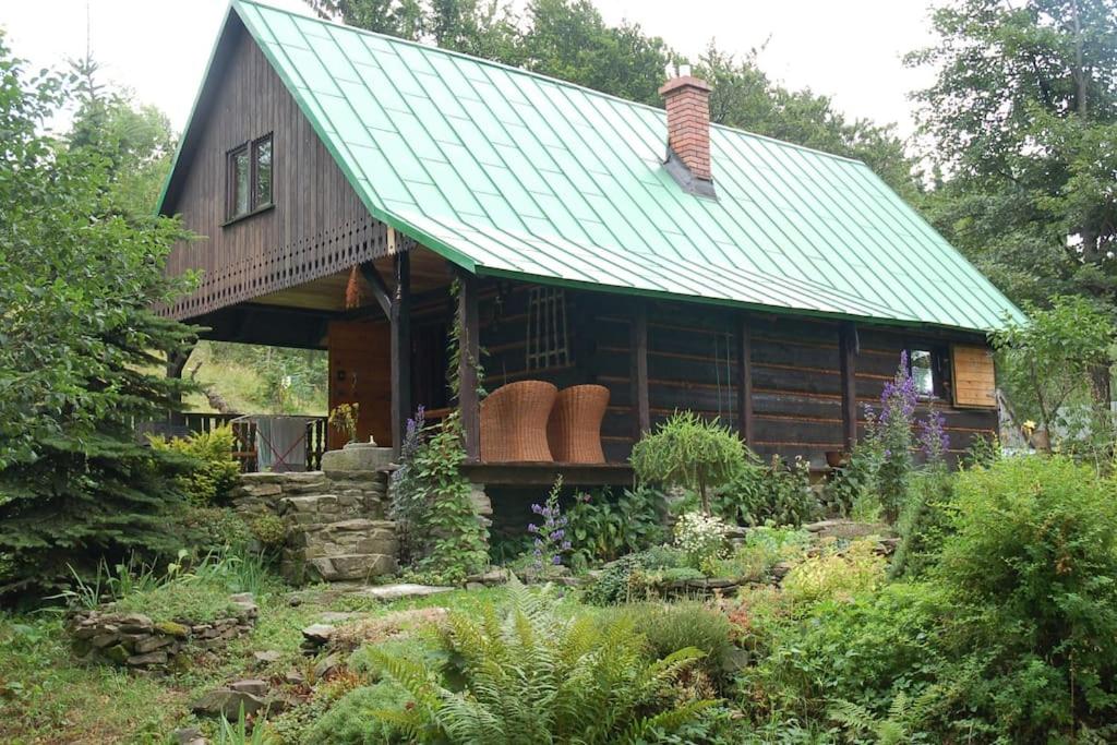 a log cabin with a green roof and a garden at Chata Trapera na Groniu in Koszarawa