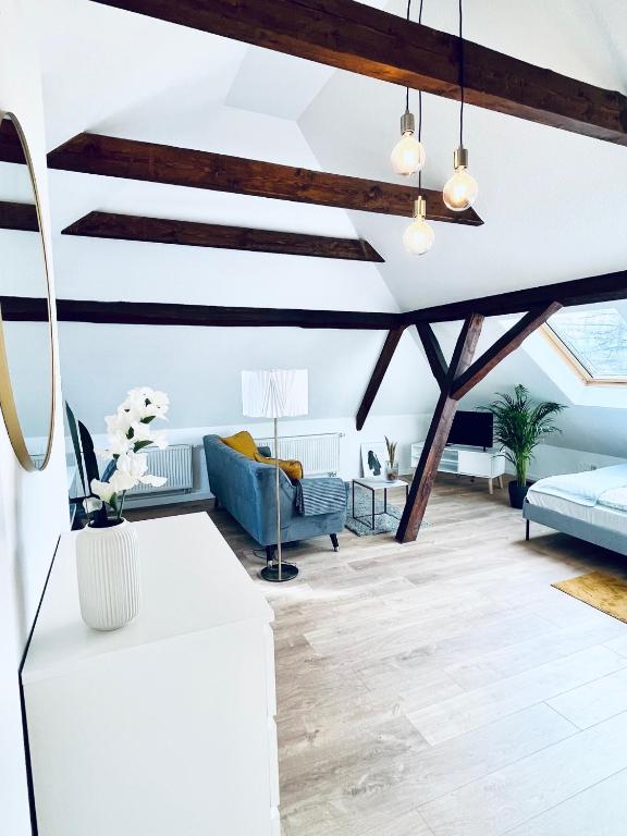a living room with exposed beams and a blue couch at Cityapartment-SmartTV-Kitchen-Car Parking Space-WLAN in Erfurt