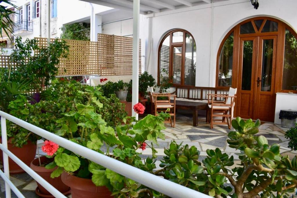 un patio con plantas, mesa y sillas en Pallada Boutique Tinos, en Tinos
