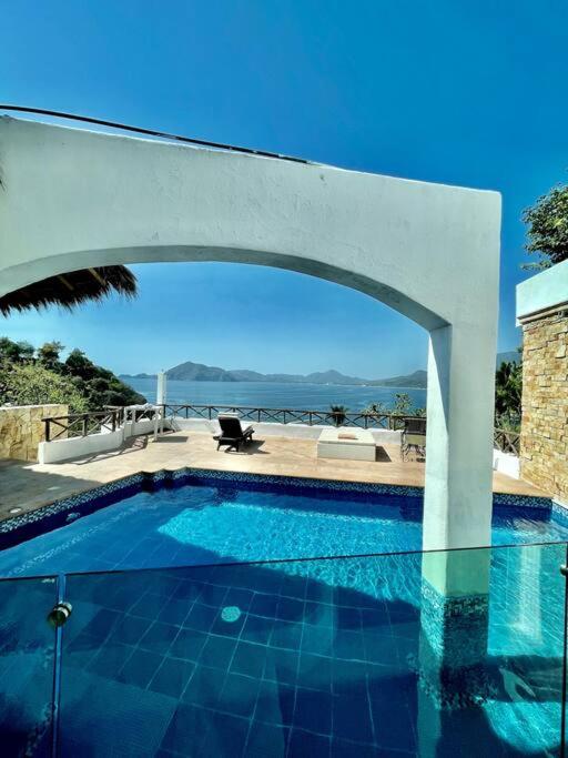 een zwembad met een boog in een huis bij Luxurious residence with sea view in Manzanillo