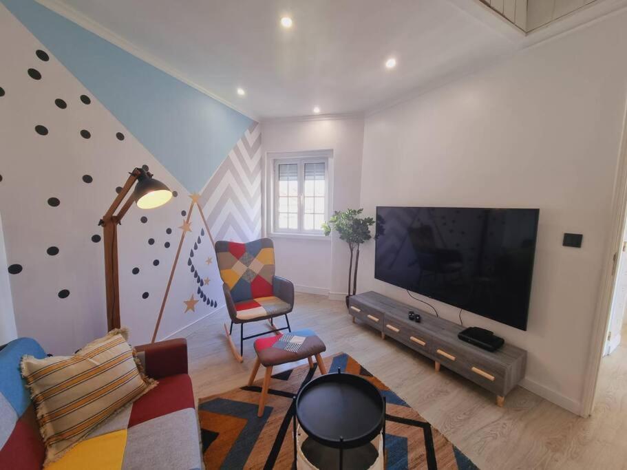 salon z telewizorem z płaskim ekranem i kanapą w obiekcie Almada central by Innkeeper w mieście Almada