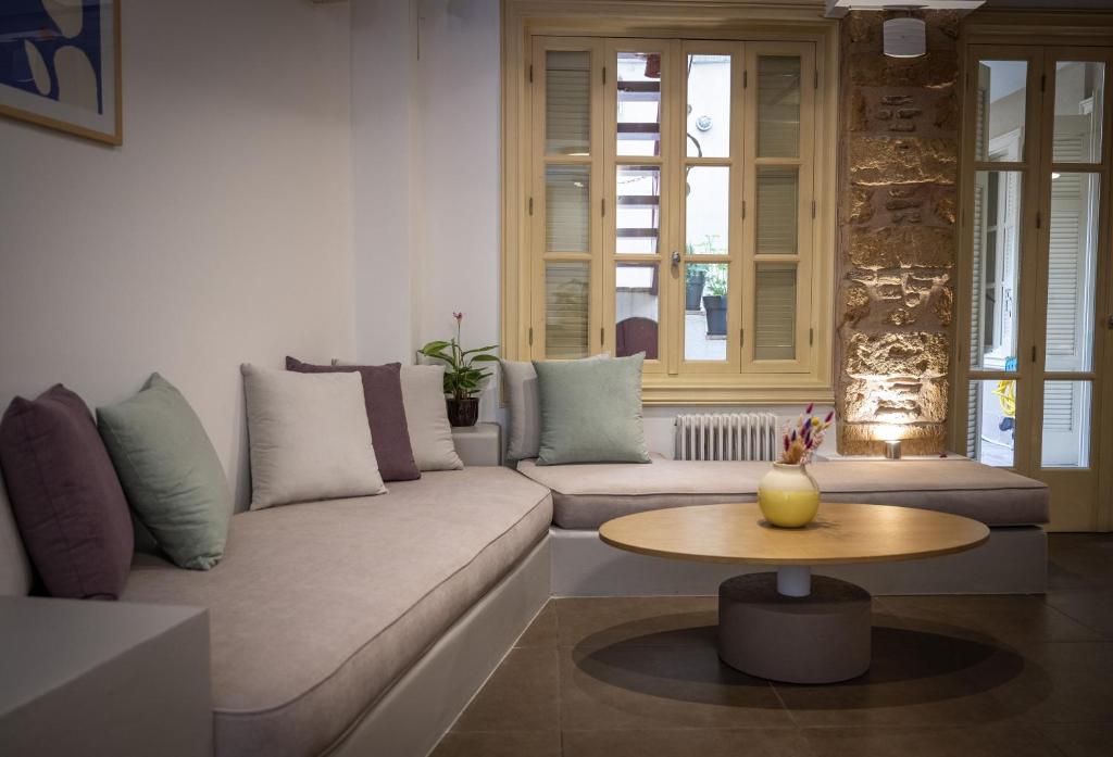 ein Wohnzimmer mit einem Sofa und einem Tisch in der Unterkunft Filopapou Pearl on Acropolis Hill in Athen