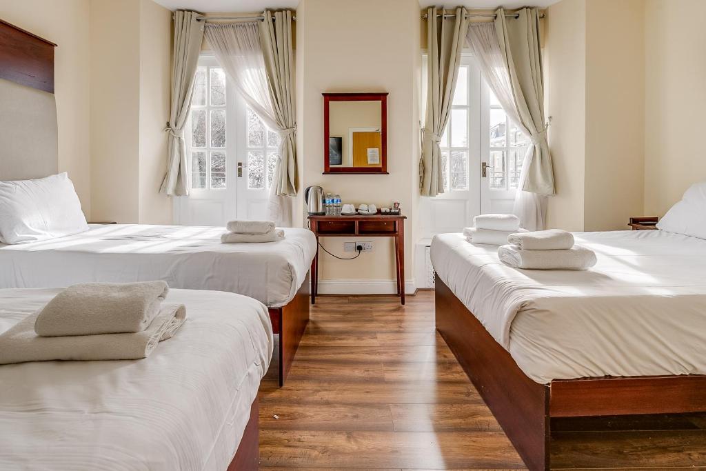 1 dormitorio con 2 camas y toallas. en Astoria Hotel, en Londres