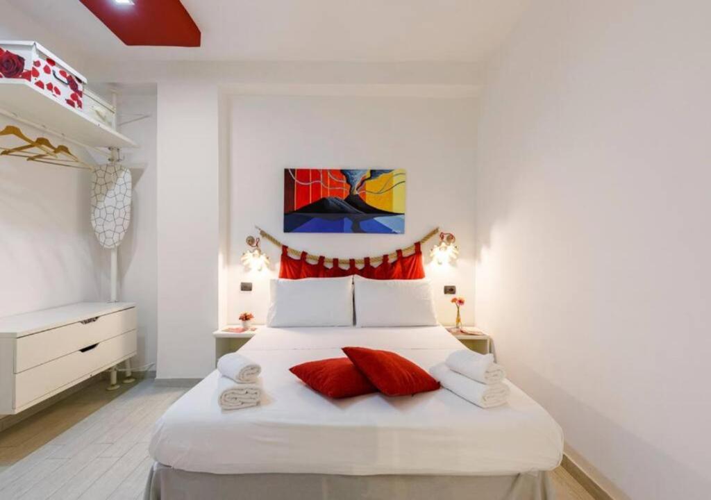 ナポリにあるApartment Duomoのベッドルーム(赤い枕の大きな白いベッド付)