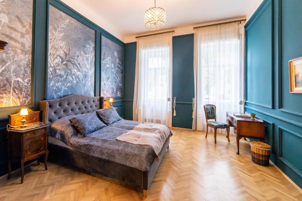 een slaapkamer met een groot bed en een bureau bij Kastély Apartman in Eger